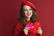 © Alliance - smiling trendy 40 years old woman in red sweater and beret
