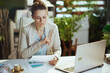 © Alliance - pensive woman worker in light business suit in green office