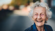 A vibrant elderly woman sporting a genuine smile that creates wrinkles around her closed eyes, laughs joyfully on a street corner