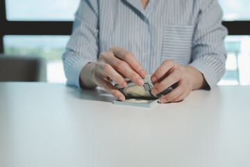 Business owner is counting money and making notes in a financial book, Financier is verifying the income received from the client's investment, Accountant calculated how much money there was in total.