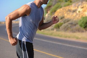 Wall Mural - Fitness, sweat and man athlete in mountain running for race, marathon or competition training. Sports, workout and body of male runner doing a cardio exercise for health or wellness in outdoor nature