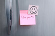 © Gatot - Sticky note with handwritten text I Love You attached to refrigerator door in kitchen. Romantic message.