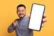 © Prostock-studio - Korean man with large blank cellphone pointing to camera, studio