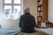 © Westend61 - Contemplative senior man sitting on bed at home