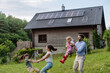 © Westend61 - Young family having fun in front their family house with solar panels on the roof