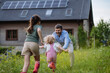© Westend61 - Father and daughters having fun in front their family house with solar panels on the roof