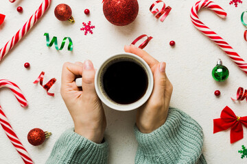 Wall Mural - Woman holding cup of coffee. Woman hands holding a mug with hot coffee. Winter and Christmas time concept