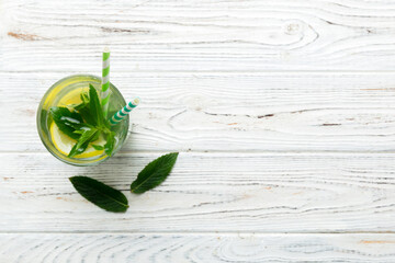 Wall Mural - Caipirinha, Mojito cocktail, vodka or soda drink with lime, mint and straw on table background. Refreshing beverage with mint and lime in glass top view flat lay