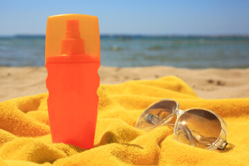 Wall Mural - Sunscreen, sunglasses and towel on sandy beach. Sun protection care