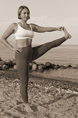 Sticker - Young beautiful woman performing balance yoga position on the beach