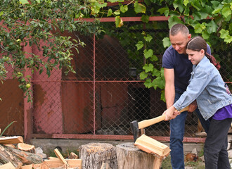 Father teaches daughter to chop wood