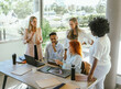© Luis - Work colleagues discussing about a new project while working together in the office.