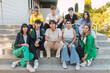 © julio - Group of diverse friends sitting on stairs of building in daylight