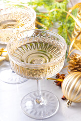 Wall Mural - Two champagne glasses on Christmas decorated background, Merry Christmas and Happy New Year greeting card background, with golden baubles and fir tree branches