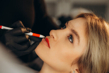 Canvas Print - Cosmetologist in black gloves making permanent makeup on woman's lips with tattoo pen machine. Microblading process