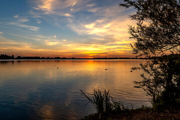 Wall Mural - View of a beautiful sunset from the shore of lake Zoetermeerse Plas, Netherlands