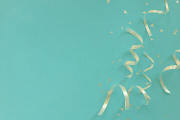 Wall Mural - close up on group of silver color of rolling ribbon and confetti on teal background with copy space 