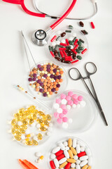 Wall Mural - Differents pills and stethoscope on white background. Medicine concept