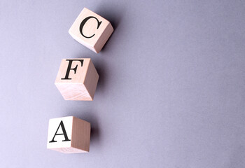 Wall Mural - Word CFA on wooden block on the grey background