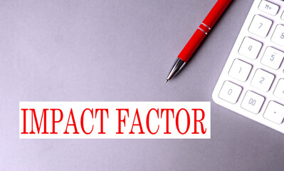 Wall Mural - IMPACT FACTOR text written on a gray background with pen and calculator