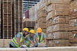 © amorn - Group of male and female warehouse workers working laptop computer at wooden warehouse storage. Team of warehouse workers discussing and training of work at shelves pallet warehouse