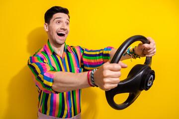 Wall Mural - Photo of young man driving first time electro automobile crazy emotions fast speed in a second isolated on yellow color background