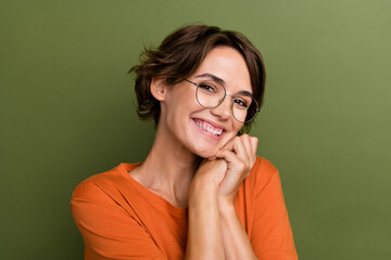 Portrait of cute young satisfied lady hands together toothy smiling pretty person dreaming looking you isolated on khaki color background