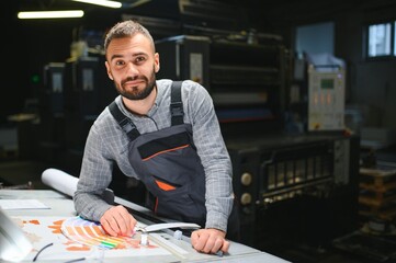 Wall Mural - Graphic engineer or worker checking imprint quality in modern print shop