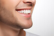 © omune - Smiling facial expression of young man. Close-up of white teeth, nose, chin and cheeks, results of regular check-up at dentist with toothbrush. Concept for vigor and liveliness, health and cleanliness