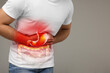 Man suffering from stomach ache on grey background, closeup and space for text. Illustration of unhealthy gastrointestinal tract