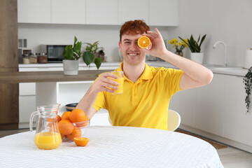 Sticker - Young man with glass of orange juice in kitchen