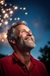 © EOL STUDIOS - A middle-aged man smiling broadly as he watches Fourth of July fireworks, his face lit by the colorful bursts in the sky, reflecting a sense of pride and joy during the Independence Day celebrations