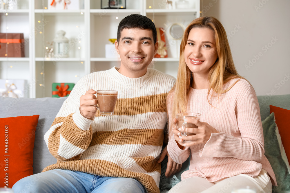Young couple with cocoa at home on Christmas eve