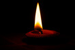 Close up of a candle on a dark background with copy space.