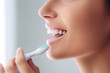© omune - White teeth of a smiling woman brushing her teeth. Brushing your teeth every day keeps them healthy, and whitening them makes them more palatable. Health, beauty and dentistry concept.