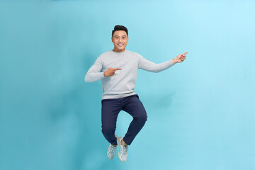 Wall Mural - Full length photo of confident pretty man jumping high thumbs up empty space