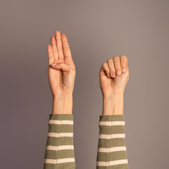 Hands raised displaying the 'Signal for Help', a covert SOS used to silently communicate distress or danger