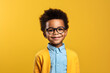 portrait of happy nerdy black boy isolated on yellow background