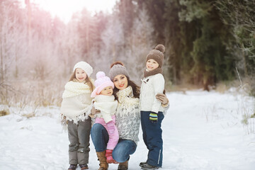 Wall Mural - Happy family playing and laughing in winter outdoors in the snow. City park winter day.