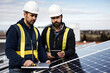 Engineers and technicians wearing helmets install solar panels using clean and renewable energy technologies.