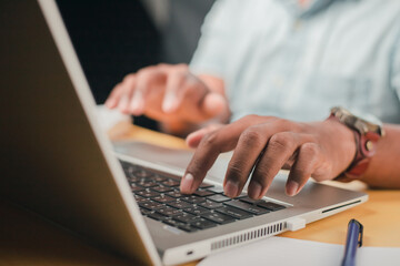 A business man is checking daily online stock market prices through a laptop at home with graphs displayed on the screen. Concept of daily business uncle	