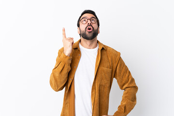 Wall Mural - Caucasian handsome man with beard wearing a corduroy jacket over isolated white background pointing up and surprised