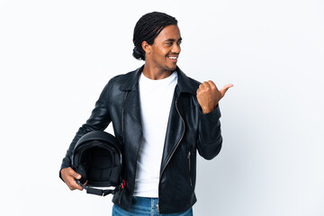 Wall Mural - African American man with braids holding a motorcycle helmet isolated on white background pointing to the side to present a product