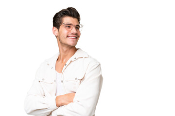 Wall Mural - Young handsome caucasian man over isolated background with arms crossed and happy