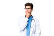 © luismolinero - Young doctor man over isolated background having doubts and with confuse face expression