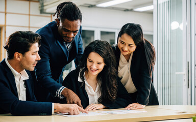 Wall Mural - A diverse international team, with a female leader, collaborates in a meeting room. They work together, analyze graphs, and discuss strategies, displaying their commitment to success. Teamwork