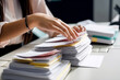Businesswoman working with stacks of paper files to search and check unfinished documents. Accountant.