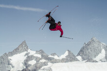 Anonymous Carefree Man Skiing And Jumping On Snowy Mountain While Enjoying Winter Day At Swiss Alps
