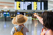 © ADDICTIVE STOCK - Siblings with departure board in airport