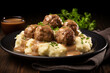traditional swedish meatballs with meat sauce and mashed potatoes on a plate, close-up. Black background.